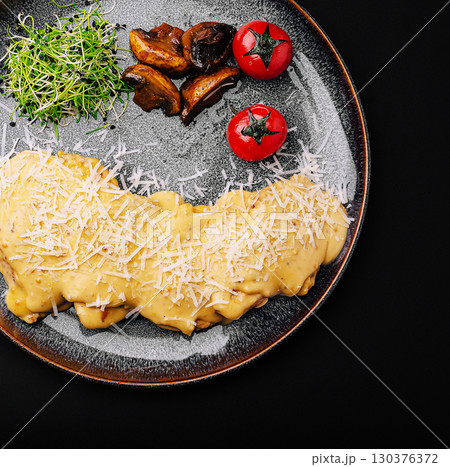 Pasta with mushrooms and cherry tomatoes on a dark background 130376372
