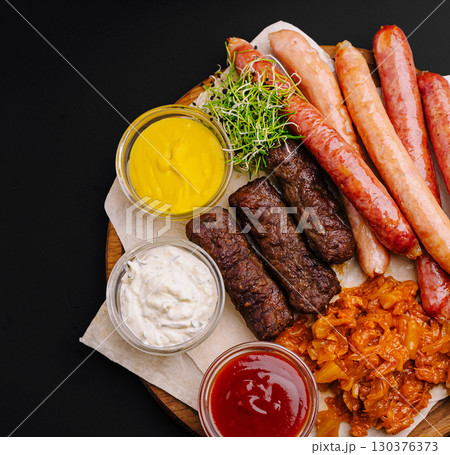 Sizzling platter of grilled meats and sauces for a hearty meal 130376373