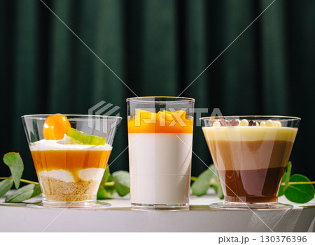 Delicious desserts displayed in elegant glasses at a cozy cafe Delicious desserts displayed in elegant glasses at a cozy cafe 130376396