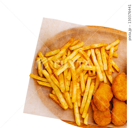 Crispy chicken nuggets and seasoned French fries served on a platter 130376441