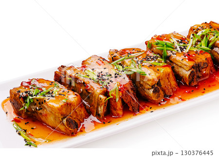 Deliciously presented pork belly drizzled with spicy sauce and garnishes Deliciously presented pork belly drizzled with spicy sauce and garnishes 130376445