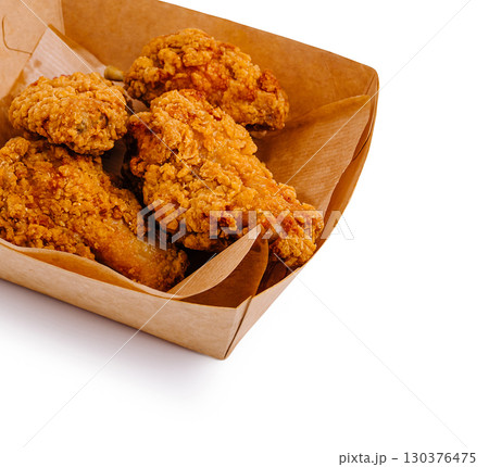 Crispy fried chicken served in a takeout container with a golden brown crust 130376475