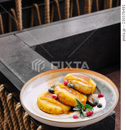 Delicious pancakes served with fresh berries in modern dining setting 130376491