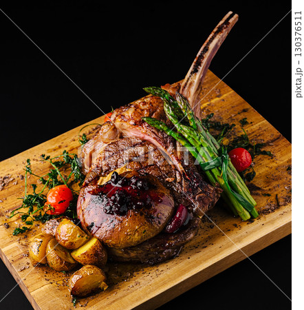 Juicy ribeye steak with roasted vegetables served on a wooden board Juicy ribeye steak with roasted vegetables served on a wooden board 130376511