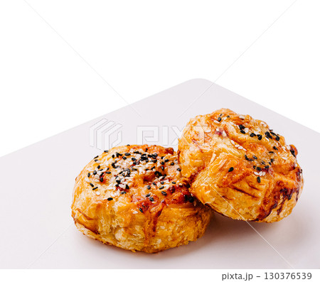 Flaky pastry treats topped with sesame seeds on a clean plate 130376539