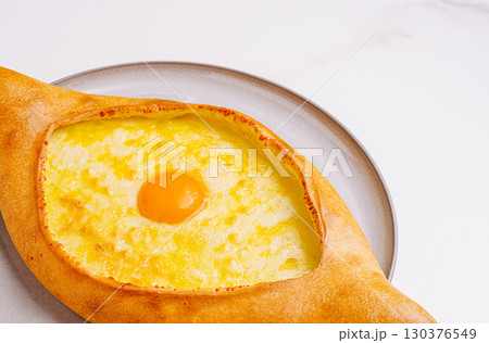 Delicious egg and cheese khachapuri served on a gray plate 130376549