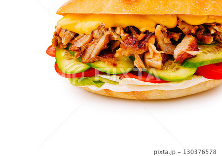 Delicious sandwich with grilled meat and fresh vegetables served in a bun Delicious sandwich with grilled meat and fresh vegetables served in a bun 130376578