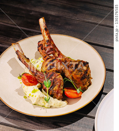 Grilled lamb chops served with creamy mashed potatoes and cherry tomatoes 130376585