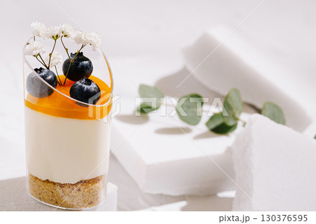 Delicious dessert with orange topping and fresh berries on a white background Delicious dessert with orange topping and fresh berries on a white background 130376595