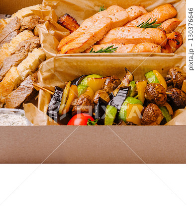 Grilled salmon and vegetable skewers served with artisan bread for lunch 130376646