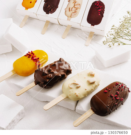 Assorted frozen desserts displayed on a white background in a kitchen setting Assorted frozen desserts displayed on a white background in a kitchen setting 130376650