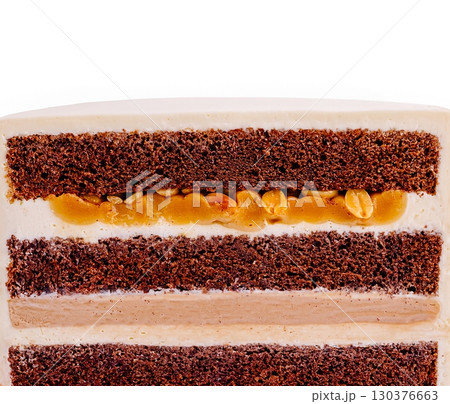 Chocolate cake layers with creamy filling and a nutty topping 130376663