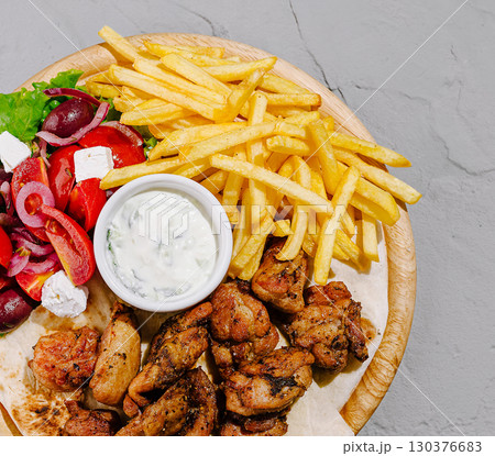 Grilled chicken platter with fries and fresh salad at the restaurant Grilled chicken platter with fries and fresh salad at the restaurant 130376683