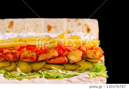Delicious wrap filled with grilled chicken, fresh vegetables, an Delicious wrap filled with grilled chicken, fresh vegetables, an 130376797