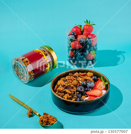 Colorful breakfast with granola and fresh fruit on a bright backdrop Colorful breakfast with granola and fresh fruit on a bright backdrop 130377007