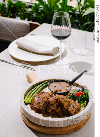 Delicious grilled steak with vegetables served in an elegant dining setting Delicious grilled steak with vegetables served in an elegant dining setting 130377043