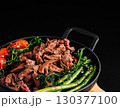 Juicy grilled steak with asparagus and cherry tomatoes served in a skillet 130377100