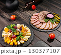 Gourmet cheese and charcuterie platter served on rustic wooden table 130377107