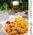 Delicious fried snacks with fries and drinks in a vibrant setting 130377112
