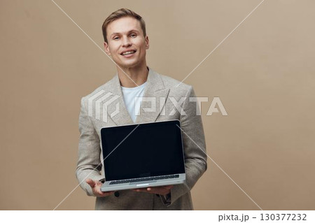 smiling young caucasian man hold laptop wear beige blazer white t-shirt stand isolated neutral background digital nomad work concept 130377232