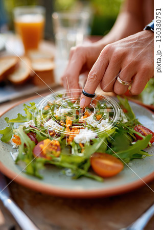 Exploring augmented reality features on a fresh salad during a sunny outdoor meal 130380751