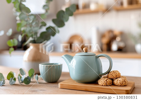 Cozy kitchen setting with wooden table featuring tea and freshly baked cookies 130380831