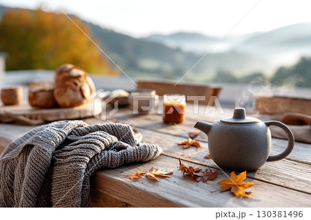Enjoying a slow breakfast on a rustic terrace with a view of foggy hills 130381496