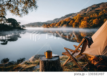 Cozy tent by tranquil lake offers peaceful morning retreat with coffee 130381497