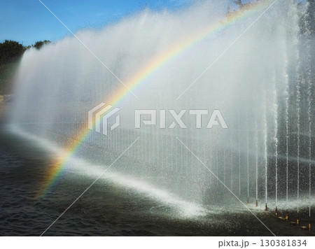 fountain with a rainbow against the blue sky 130381834