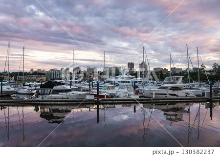 Luxury boats and yachts rest in the touristic port. Sunset light. Beautiful sunset view of yacht harbor and sailboat at dock with wonderful sunset sky. Travel photo, nobody Luxury boats and yachts rest in the touristic port. Sunset light. Beautiful sunset view of yacht harbor and sailboat at dock with wonderful sunset sky. Travel photo, nobody 130382237