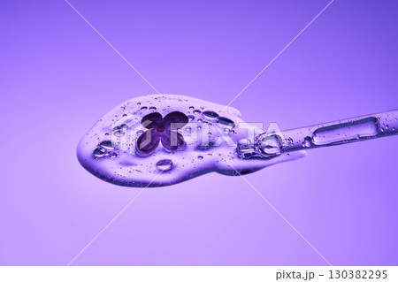The texture of a serum with a dropper and a lilac flower. 130382295