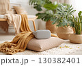 Headset resting on a yoga cushion in a serene indoor space with plants and cozy decor 130382401