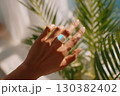 Smart ring mockup showcasing design on hand reaching toward sunlight with tropical foliage 130382402
