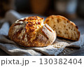 Freshly baked grain sourdough bread with seeds resting on linen cloth 130382404