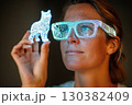 Individual wearing neon VR glasses interacts with glowing figure in a dimly lit space 130382409