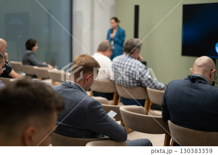 Business professionals attending a conference session with speaker in focus 130383359