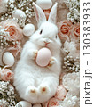Easter Bunny with a pink egg on among flowers on pink background. 130383933