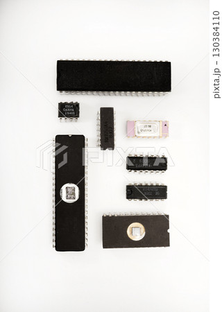Several different chips on a white background. Old electronic chips. Several different chips on a white background. Old electronic chips. 130384110