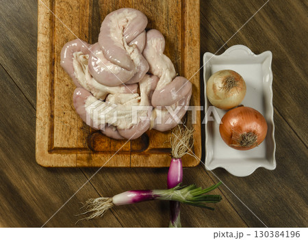 Cow bowels presented on a wooden board with ingredients, ready to grill 130384196