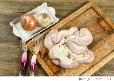 Cow bowels presented on a wooden board with ingredients, ready to grill 130384285