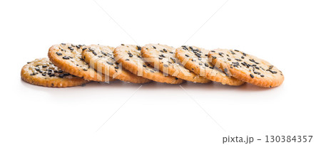 Crispy round salted crackers with sesame seeds isolated on white background. 130384357