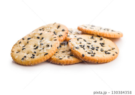 Crispy round salted crackers with sesame seeds isolated on white background. Crispy round salted crackers with sesame seeds isolated on white background. 130384358