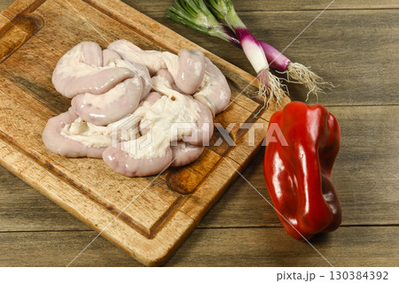 Cow bowels presented on a wooden board with ingredients, ready to grill 130384392