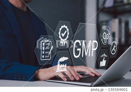 GMP compliance and quality assurance in manufacturing. Businessman working on laptop with icons represent GMP compliance, quality control, certification, manufacturing standards in corporate setting, 130384601