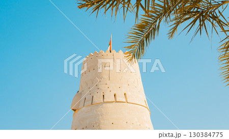 Stone arabic watchtower with waving United Arab Emirates National Flag in Al Jazirah Al Hamra haunted town in Ras Al Khaimah. High quality photo Stone arabic watchtower with waving United Arab Emirates National Flag in Al Jazirah Al Hamra haunted town in Ras Al Khaimah. High quality photo 130384775