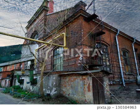 A brick building with a yellow pipe on top of it. 130384963