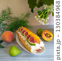A fruit cake with figs and oranges on top of a white plate. 130384968