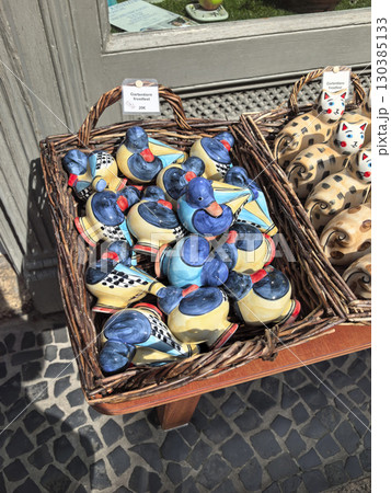 Colorful ceramic ducks displayed for sale in a quaint market stall 130385133