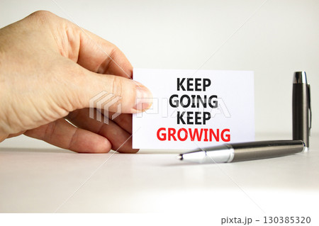 Keep going and growing symbol. Concept words phrase Keep going keep growing on beautiful card. Businessman's hand. Beautiful white paper background. Business Keep going and growing concept. Copy space 130385320