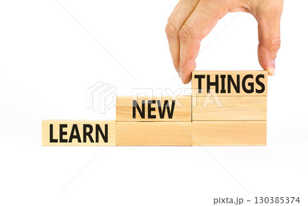 Learn new things symbol. Concept words Learn new things on beautiful wooden blocks. Beautiful white table white background. Businessman hand. Business motivational learn new things concept. Copy space 130385374